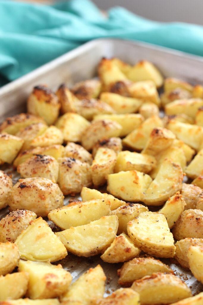close up of a baking tray spread with roasted little potatoes