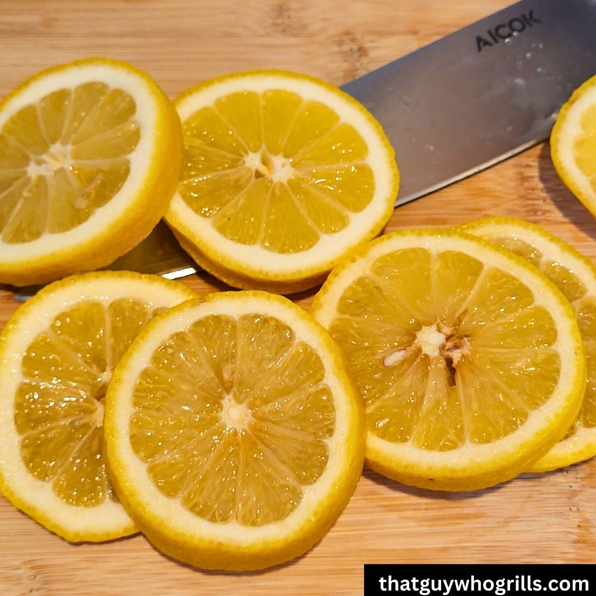 Sliced lemons on a cutting board with a knife